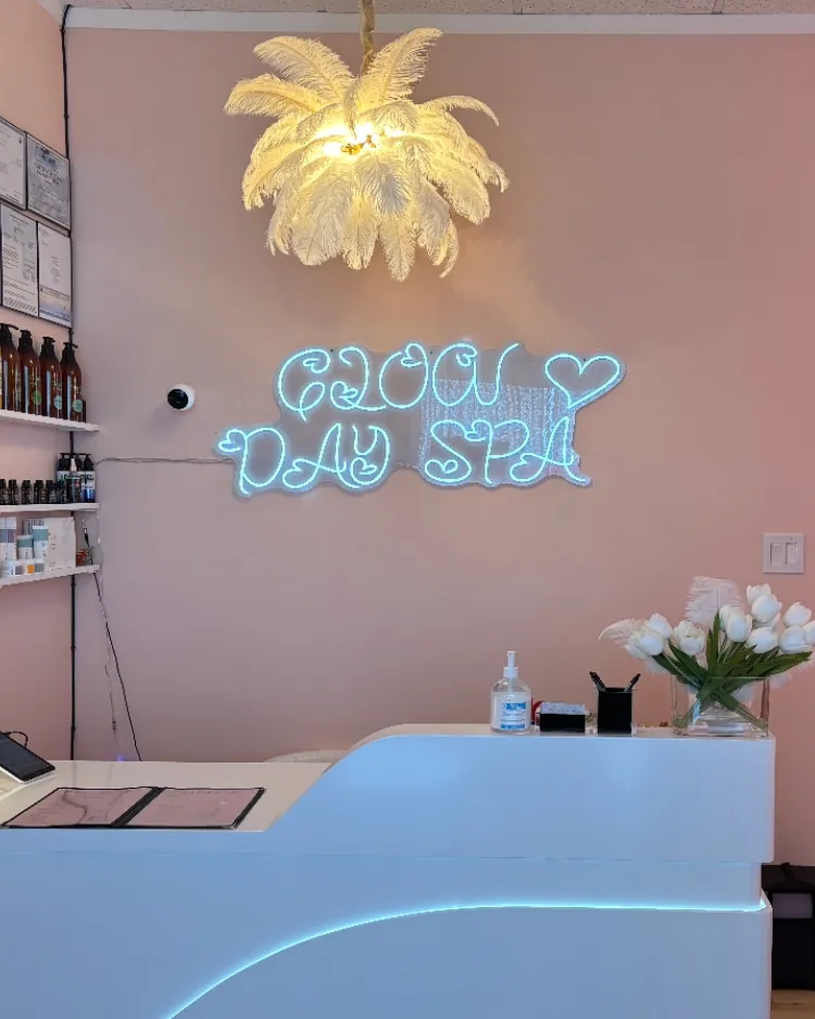 The bright pink front desk and neon Glow Day Spa sign